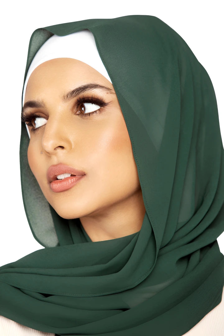 Woman wearing a green hijab on a white background