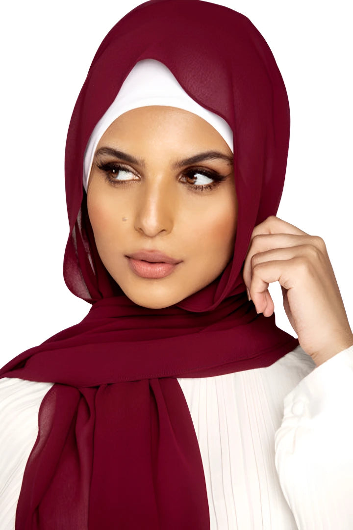 Woman wearing a burgundy hijab with a white background