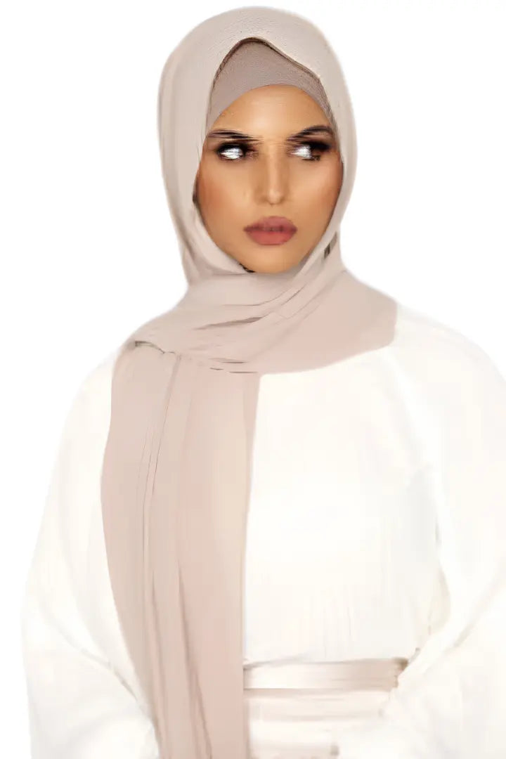 Woman wearing a beige hijab on a white background