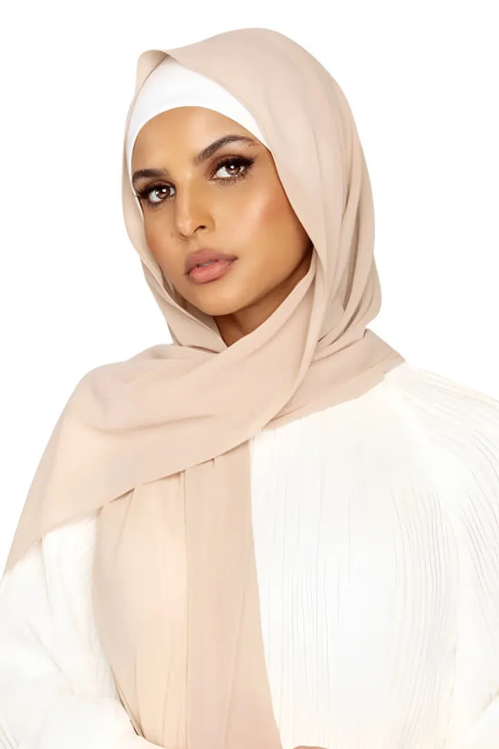 Woman wearing a beige hijab on a white background