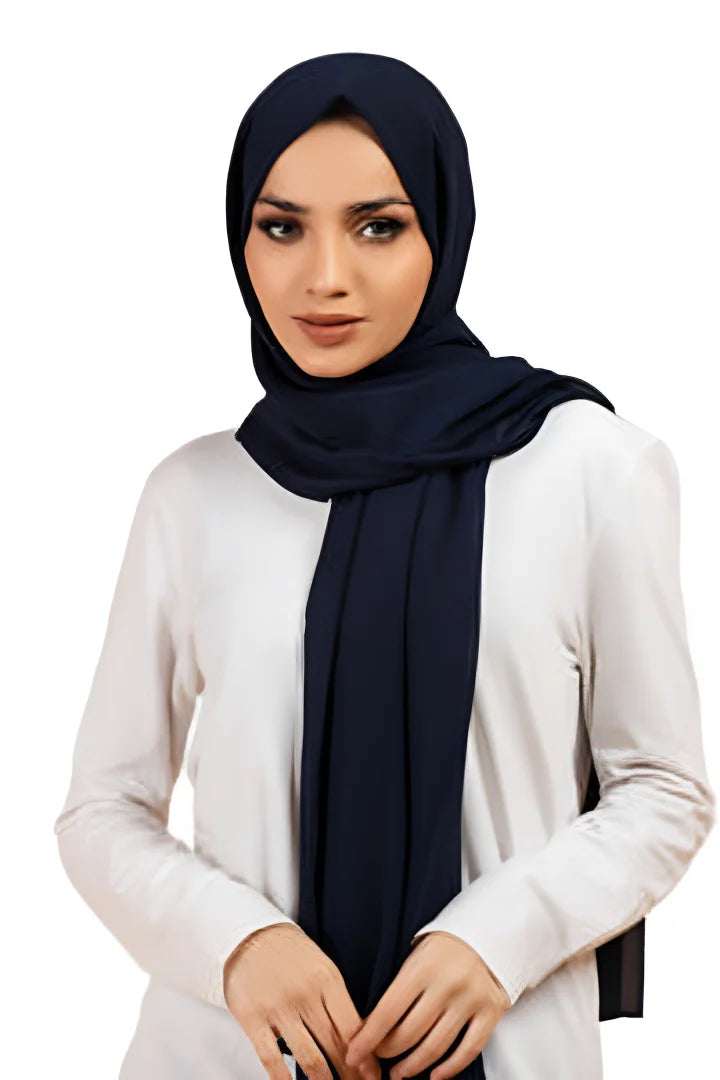 Woman wearing a navy hijab and white top on a white background