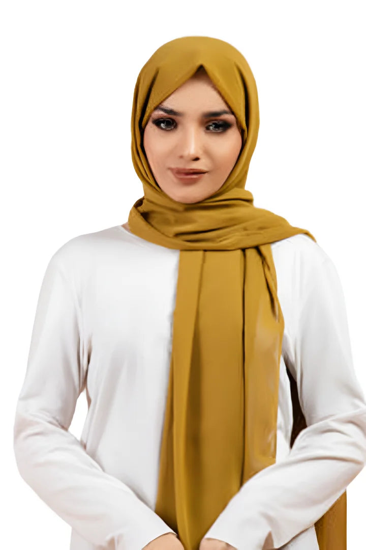 Woman wearing a mustard hijab and white top on a white background