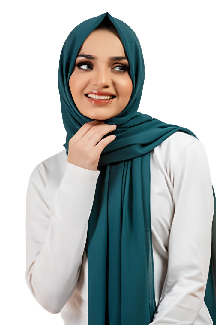 Woman wearing a teal hijab and white top on a white background