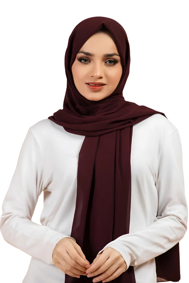 Woman wearing a dark red hijab on a white background