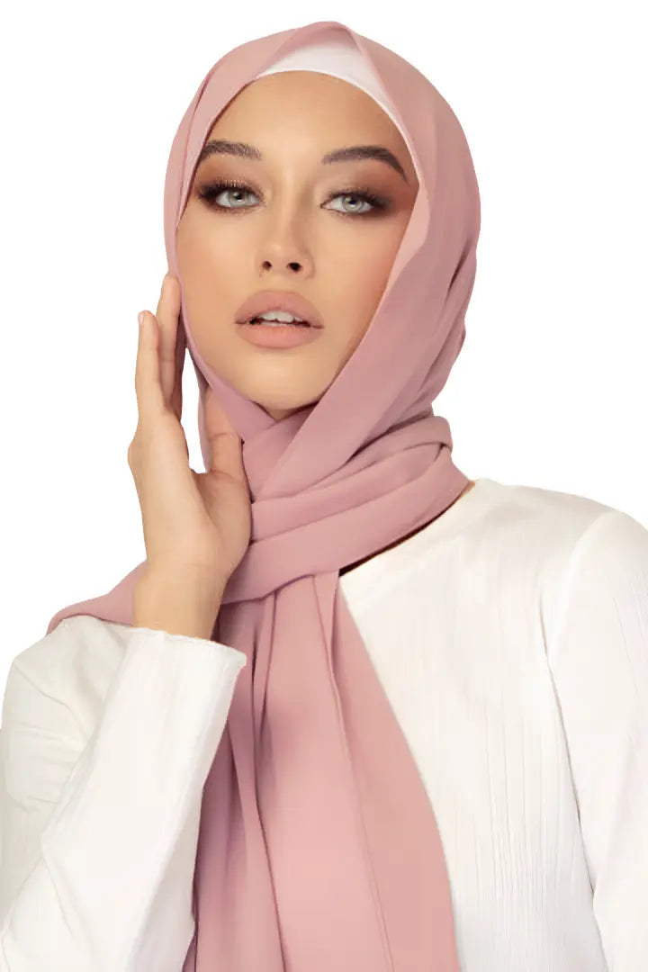 Woman wearing a pink hijab against a white background