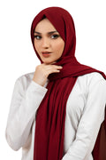 Woman wearing a red hijab and white shirt on a white background