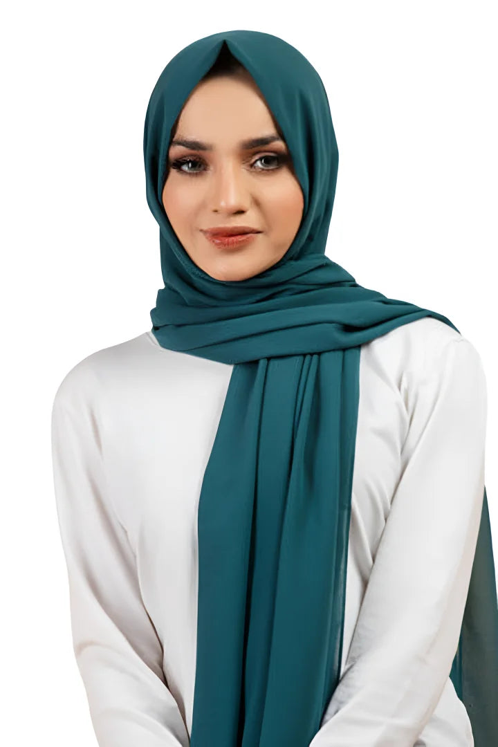 Woman wearing a teal hijab and white top on a white background
