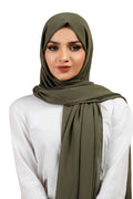 Woman wearing an olive green hijab on a white background
