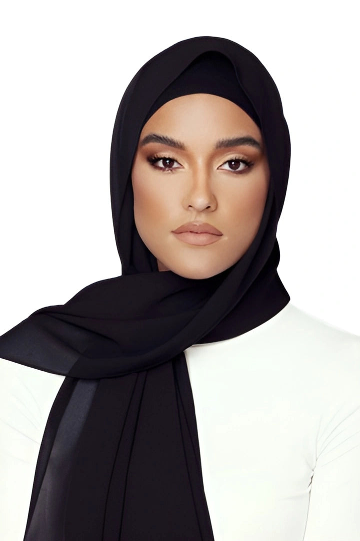 Woman wearing a black hijab on a white background
