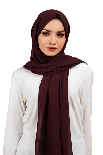Woman wearing a dark red hijab on a white background