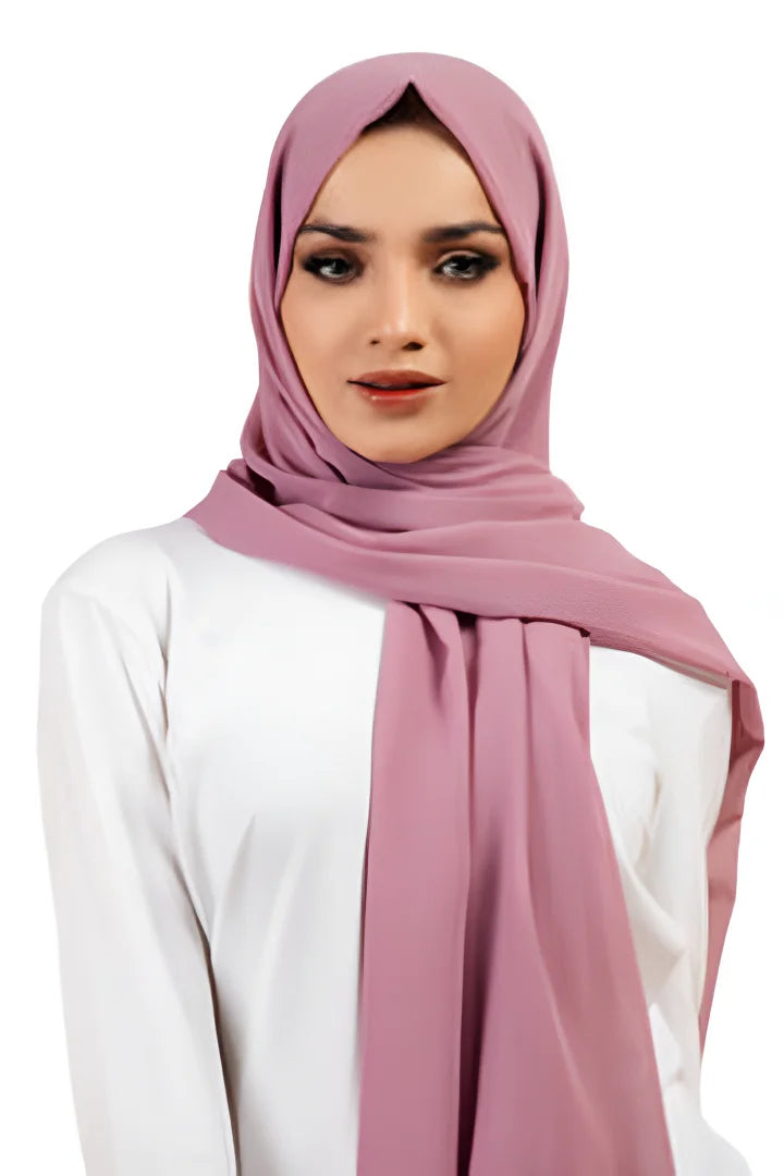 Woman wearing a pink hijab and white top on a white background
