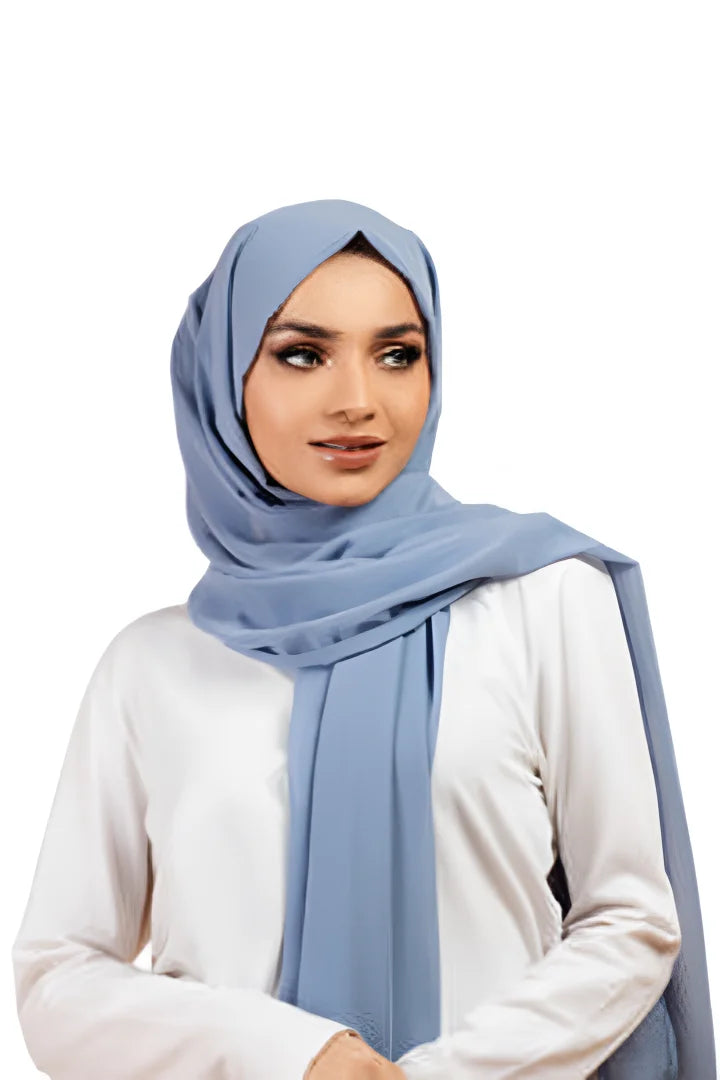 Woman wearing a light blue hijab and white shirt on a white background