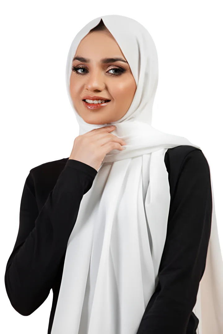 Woman wearing a white hijab and black top on a white background