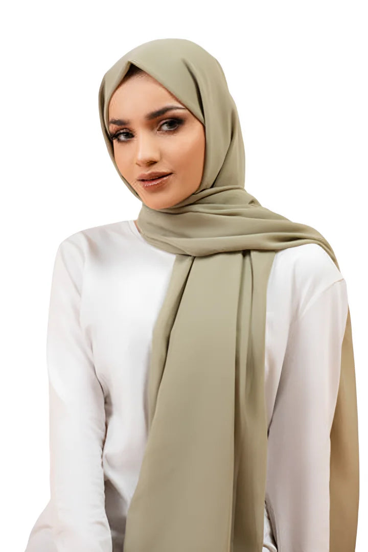 Woman wearing a beige hijab and white top on a white background