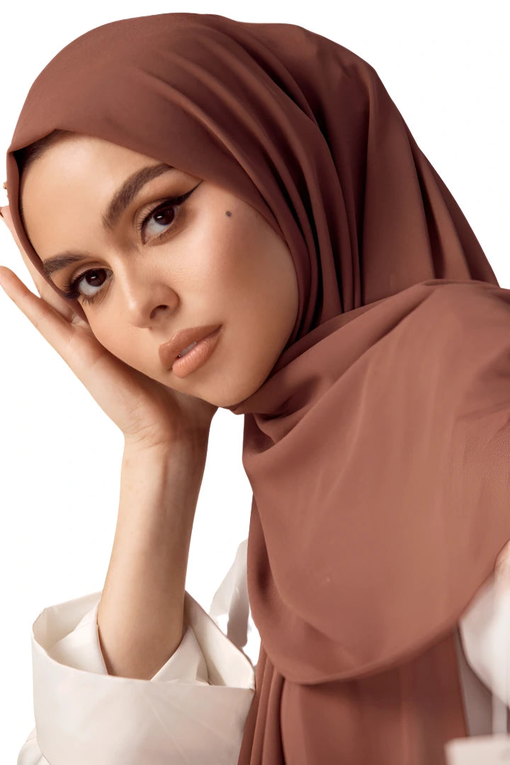 Woman wearing a brown hijab on a white background