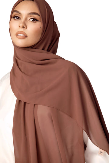 Woman wearing a brown hijab on a white background