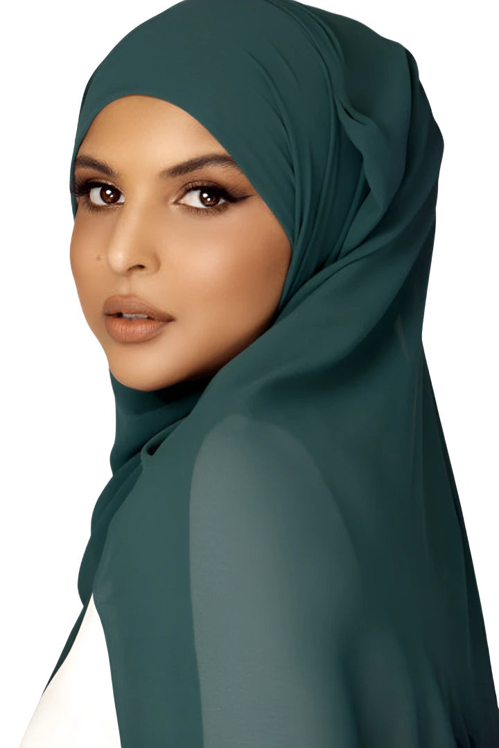 Woman wearing a dark green hijab on a white background
